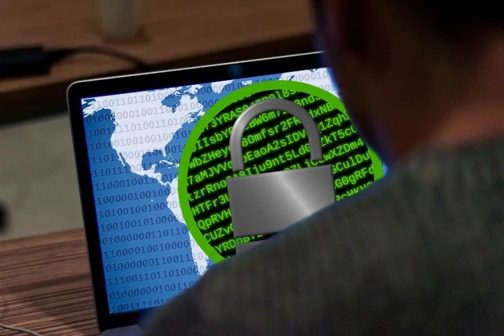 Person blickt auf einen Notebook-Monitor, auf dem bildschirmfüllend Symbole für Dateien angezeigt werden, die durch Ransomware verschlüsselt wurden.
